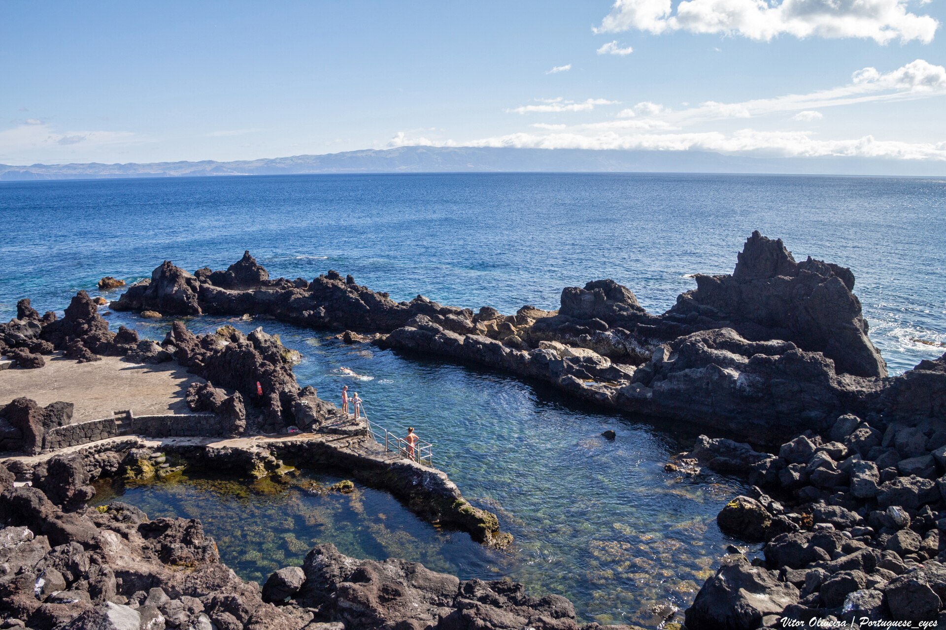 Swimming pools cut into black lava rock at the water's edge at Cais do Pico