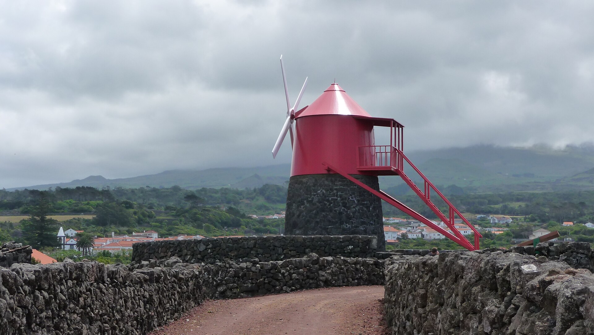 A red-capped stone windmill standing among the walled vine plots at Criação Velha